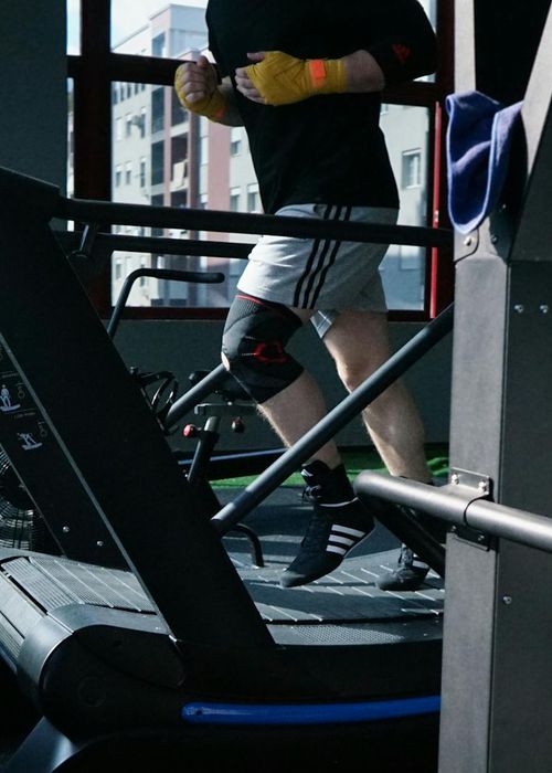 Athletic person doing high knee cardio exercise outdoors during sunrise.